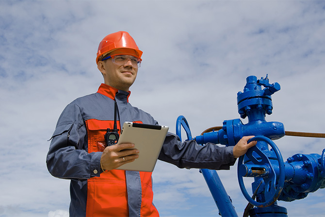 Man in safety gear holding tablet